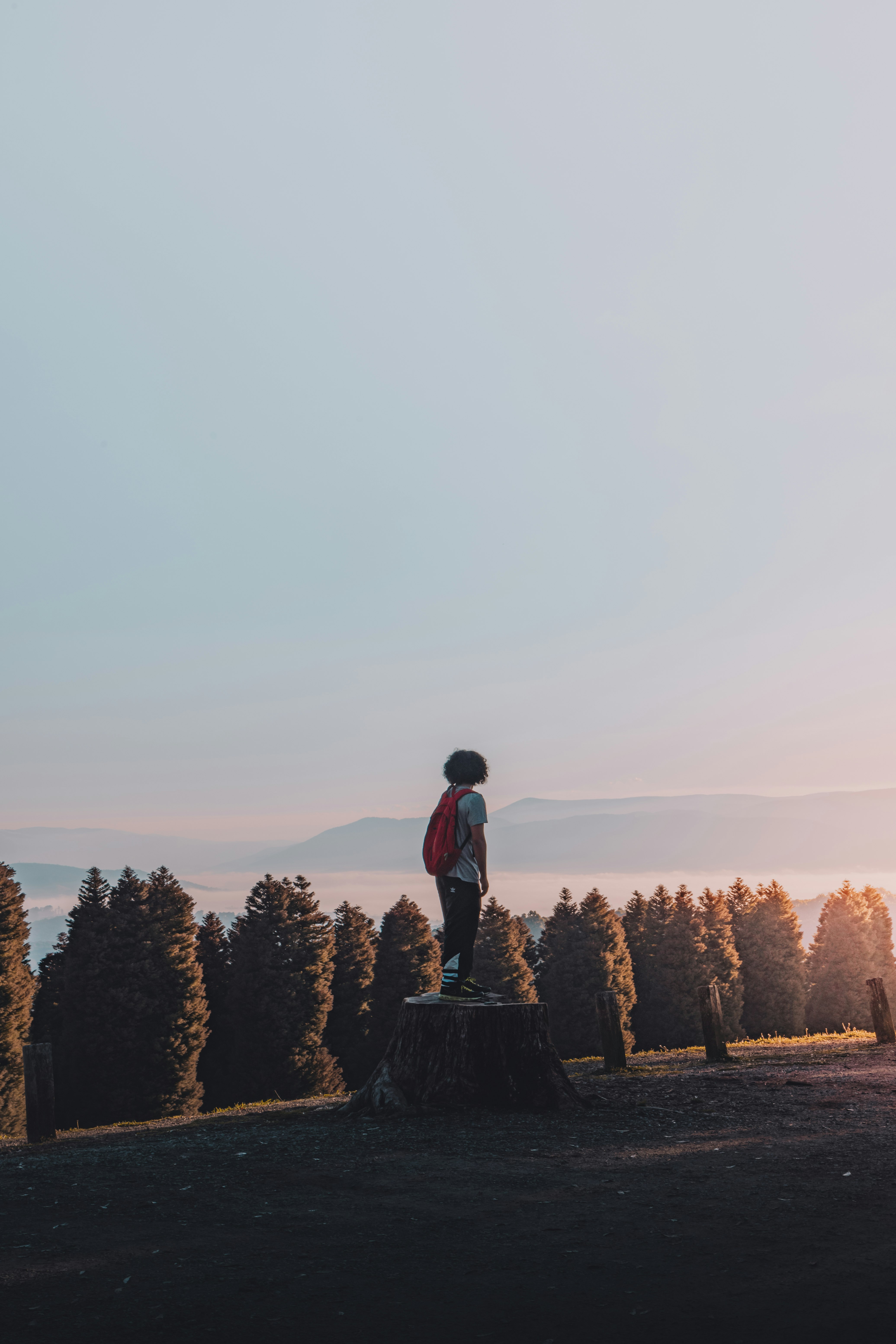 man in black jacket standing on brown rock during daytime